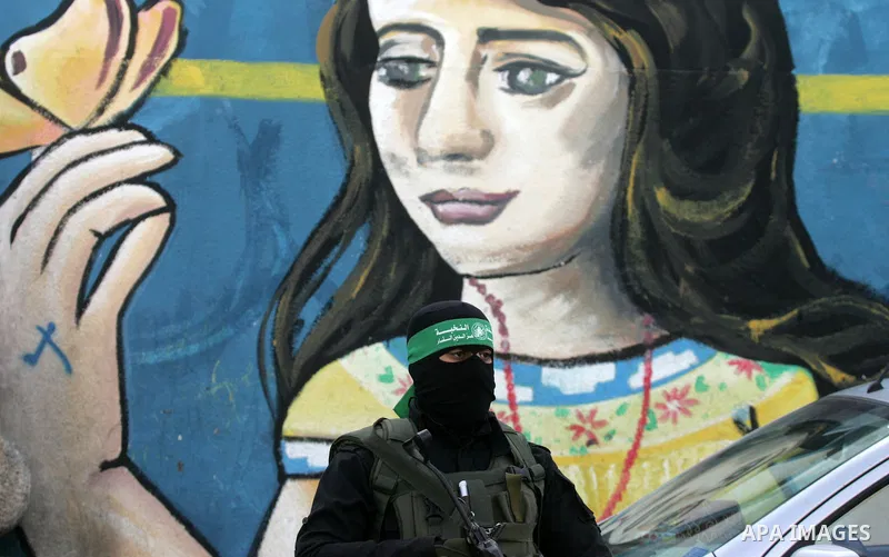 Members of the Ezzedine al-Qassam Brigades, the military wing of the Palestinian Islamist movement Hamas, take part in a rally marking the 29th anniversary of the founding of the Hamas movement, in Rafah in the southern...