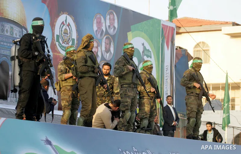 Members of the Ezzedine al-Qassam Brigades, the military wing of the Palestinian Islamist movement Hamas, take part in a rally marking the 29th anniversary of the founding of the Hamas movement, in Rafah in the southern...