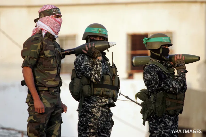 Members of the Ezzedine al-Qassam Brigades, the military wing of the Palestinian Islamist movement Hamas, take part in a rally marking the 29th anniversary of the founding of the Hamas movement, in Rafah in the southern...