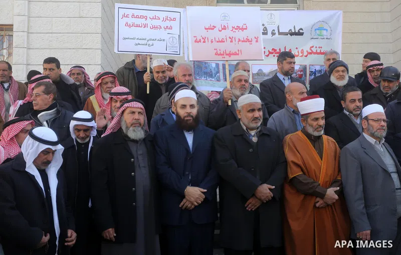 Members of the Palestine Scholars Association take part in a protest to solidarity with the inhabitants of the embattled Syrian city of Aleppo, in Gaza city, on December 17, 2016. Photo by Mohammed Asad