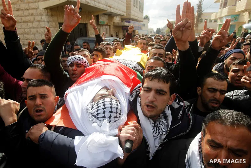 Mourners carry the body of Palestinian Firas Khdoor, who according to the Israeli military was shot dead after he carried out a car ramming attack last September, during his funeral after Israel released his body, in the...