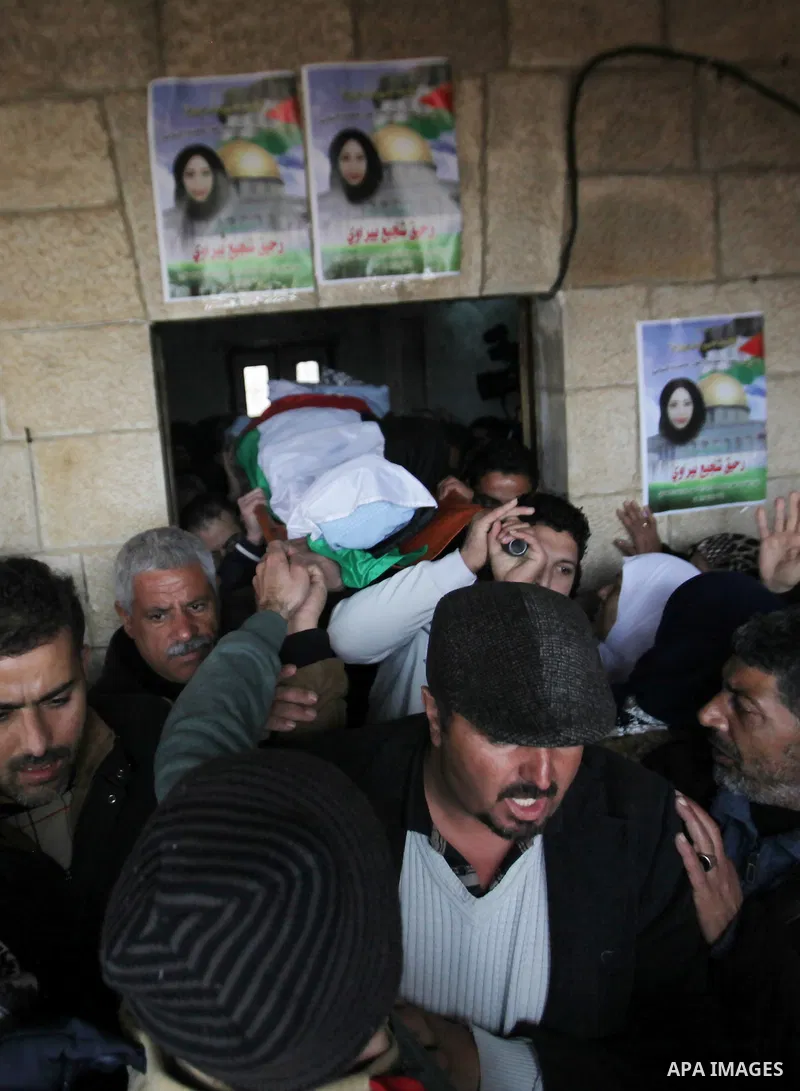 Mourners carry the body of Palestinian Rahiq Birawi, who according to the Israeli police was shot dead after she had advanced towards them with a knife in her hand at a checkpoint last October, during her funeral after I...
