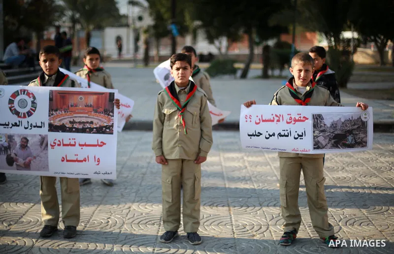 Palestinain Scouts take part in a protest to solidarity with the inhabitants of the embattled Syrian city of Aleppo, in Gaza city, on December 17, 2016. Photo by Mohammed Asad