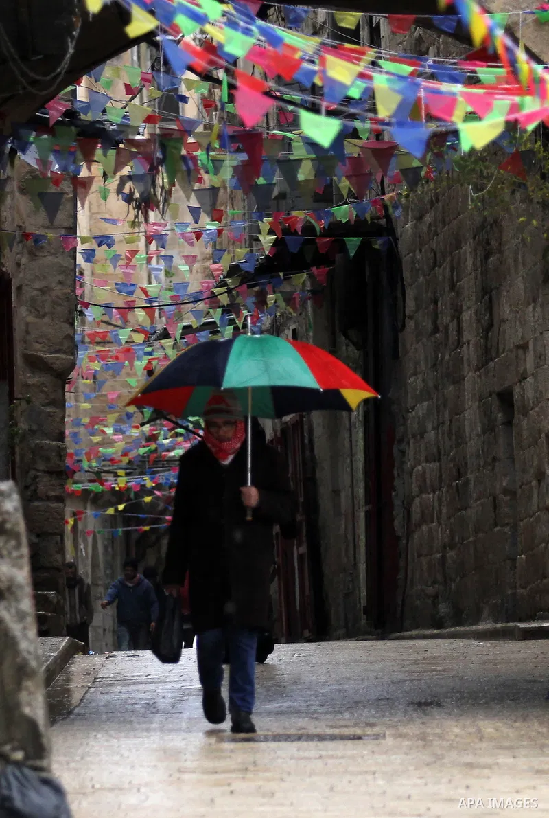 A Palestinian man walks with his umbrella under the rain, during a winter storm, in the West Bank city of Nablus, on December 18, 2016. Photo by Nedal Eshtayah