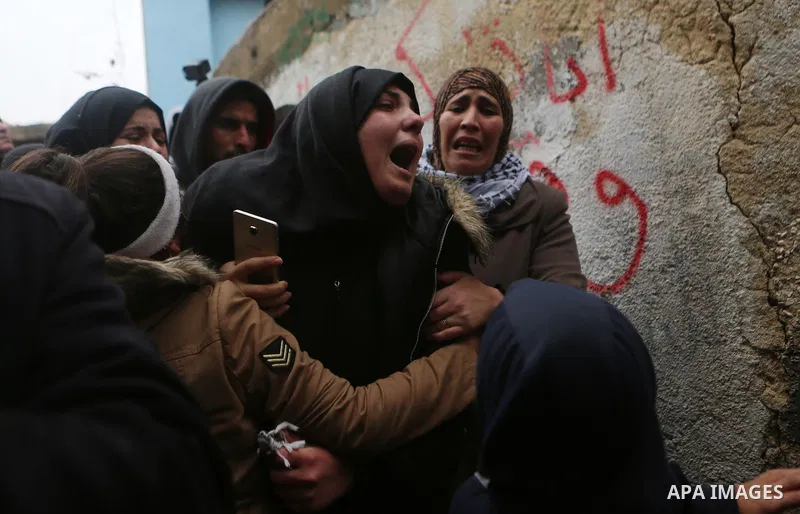 Relatives of Palestinian Ahmed al-Remawi, who Palestinian Health Ministry said was shot and killed by Israeli forces on Sunday, mourn during his funeral in the West Bank village of Beit Rima near Ramallah December 18, 20...