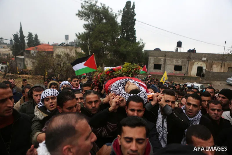 Mourners carry the body of Palestinian Ahmed al-Remawi, who Palestinian Health Ministry said was shot and killed by Israeli forces on Sunday, during his funeral in the West Bank village of Beit Rima near Ramallah Decembe...