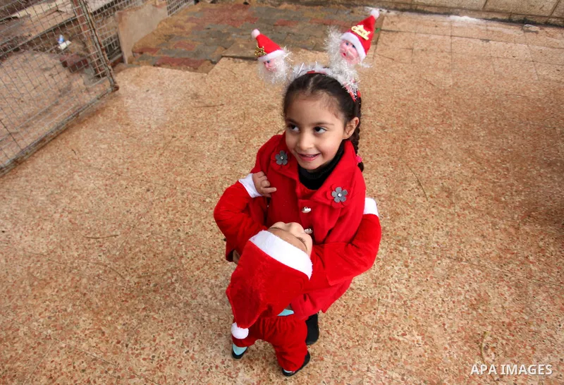 Palestinian girls dressed as Santa Claus attend a mass ahead of Christmas at Der Latin church in Gaza City on December 18, 2016. Photo by Ashraf Amra