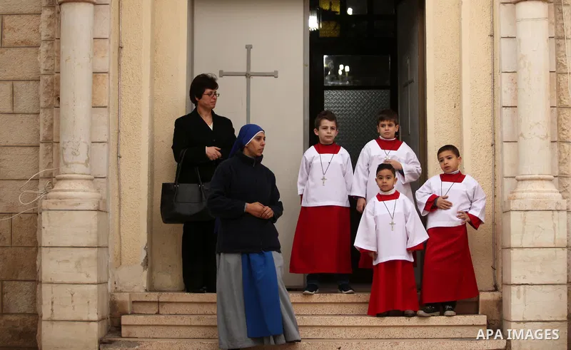 Palestinian Christians wait the arrival of English cardinal Vincent Nichols, Archbishop of Westminster, to lead a Sunday mass at Der Latin church in Gaza City on December 18, 2016. Photo by Ashraf Amra
