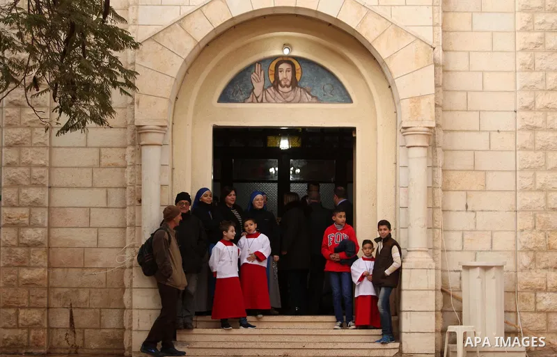 Palestinian Christians wait the arrival of English cardinal Vincent Nichols, Archbishop of Westminster, to lead a Sunday mass at Der Latin church in Gaza City on December 18, 2016. Photo by Ashraf Amra