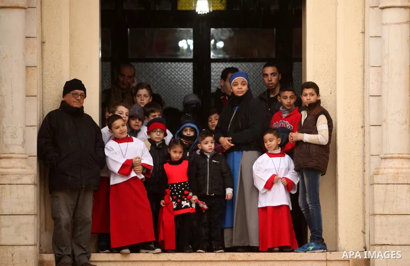 Palestinian Christians wait the arrival of English cardinal Vincent Nichols, Archbishop of Westminster, to lead a Sunday mass at Der Latin church in Gaza City on December 18, 2016. Photo by Ashraf Amra