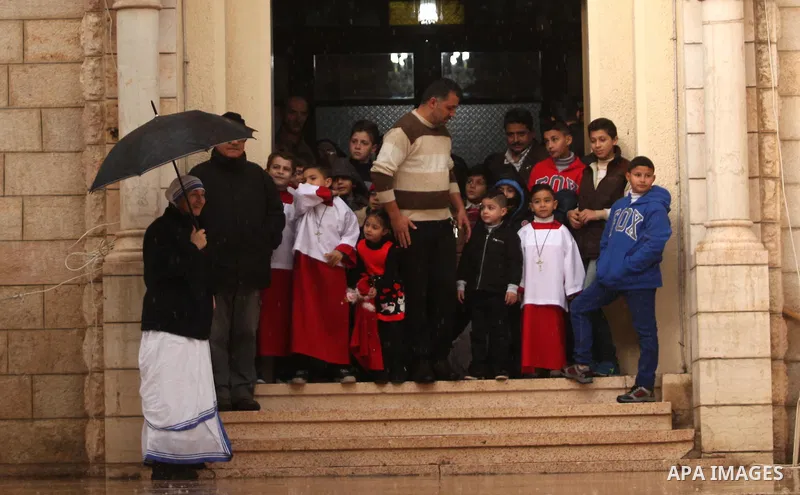 Palestinian Christians wait the arrival of English cardinal Vincent Nichols, Archbishop of Westminster, to lead a Sunday mass at Der Latin church in Gaza City on December 18, 2016. Photo by Ashraf Amra