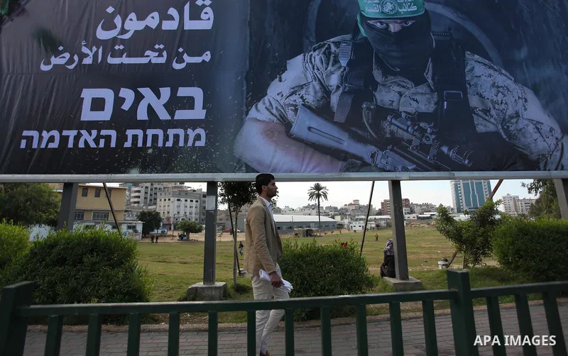 A Palestinian man walks past a mural depicting a Member of the Ezzedine al-Qassam Brigades, the military wing of the Palestinian Islamist movement Hamas, in Gaza city, on December 18, 2016. The Palestinian Hamas movement...