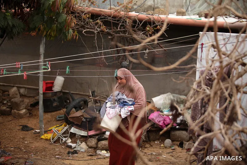 A Palestinian woman hangs laundry on a rope to dry outside her dwelling in Khan Younis in the southern Gaza Strip December 19, 2016. Photo by Ashraf Amra