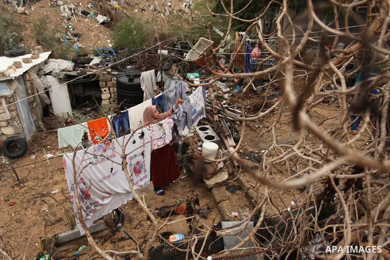 A Palestinian woman hangs laundry on a rope to dry outside her dwelling in Khan Younis in the southern Gaza Strip December 19, 2016. Photo by Ashraf Amra