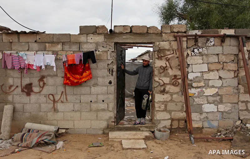 A Palestinian man standa outside his dwellings in Khan Younis in the southern Gaza Strip December 19, 2016. Photo by Ashraf Amra