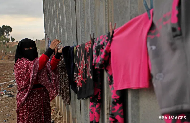A Palestinian woman hangs laundry on a rope to dry outside her dwelling in Khan Younis in the southern Gaza Strip December 19, 2016. Photo by Ashraf Amra