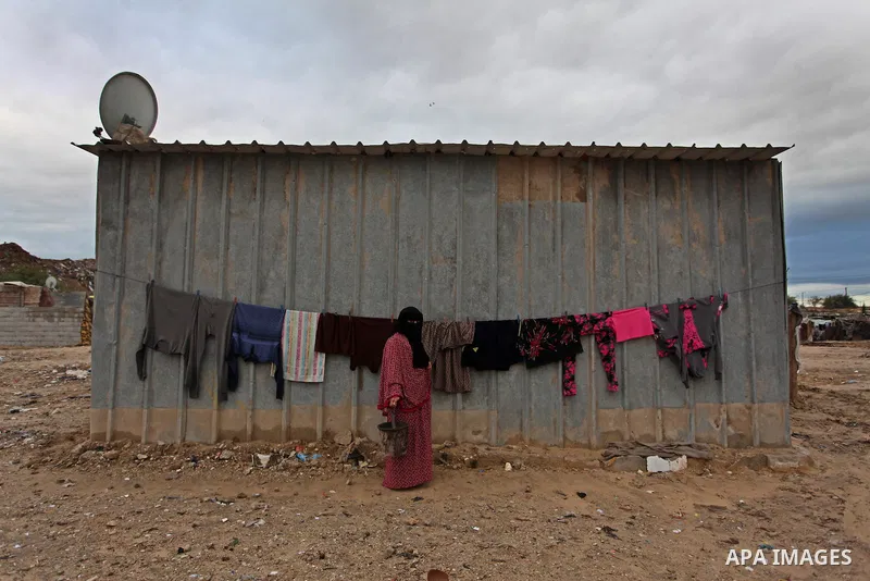 A Palestinian woman hangs laundry on a rope to dry outside her dwelling in Khan Younis in the southern Gaza Strip December 19, 2016. Photo by Ashraf Amra