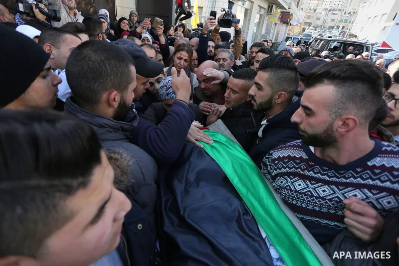 Palestinian mourners carry the body of Ahmad al-Kharoubi, 19, who was shot and killed during clashes with Israeli soldiers on December 22, 2016 during his funeral in the West Bank city of Ramallah. The Palestinian man wa...
