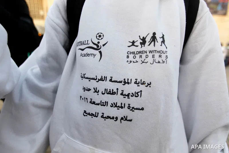 Palestinian Christian children take part at the ninth annual Christmas march past a Christmas tree at the Manger Square near the Church of the Nativity, revered as the site of Jesus Christ's birth, on December 22, 2016 i...