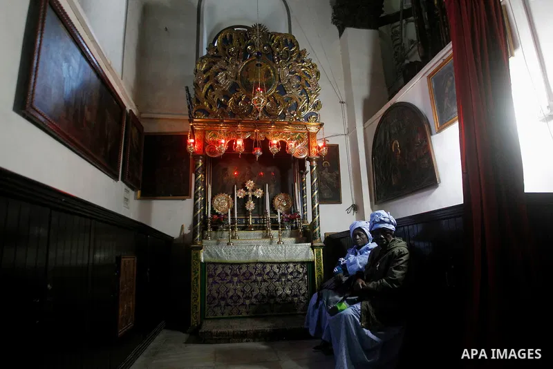 Africans Christian pilgrims pray at the Grotto in the Church of the Nativity, believed to be the birthplace of Jesus Christ, in the West Bank city of Bethlehem on December 22, 2016. Photo by Wisam Hashlamoun