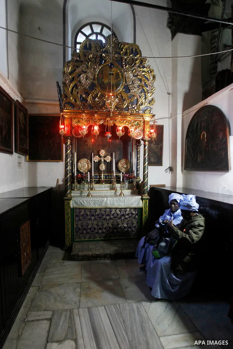 Africans Christian pilgrims pray at the Grotto in the Church of the Nativity, believed to be the birthplace of Jesus Christ, in the West Bank city of Bethlehem on December 22, 2016. Photo by Wisam Hashlamoun
