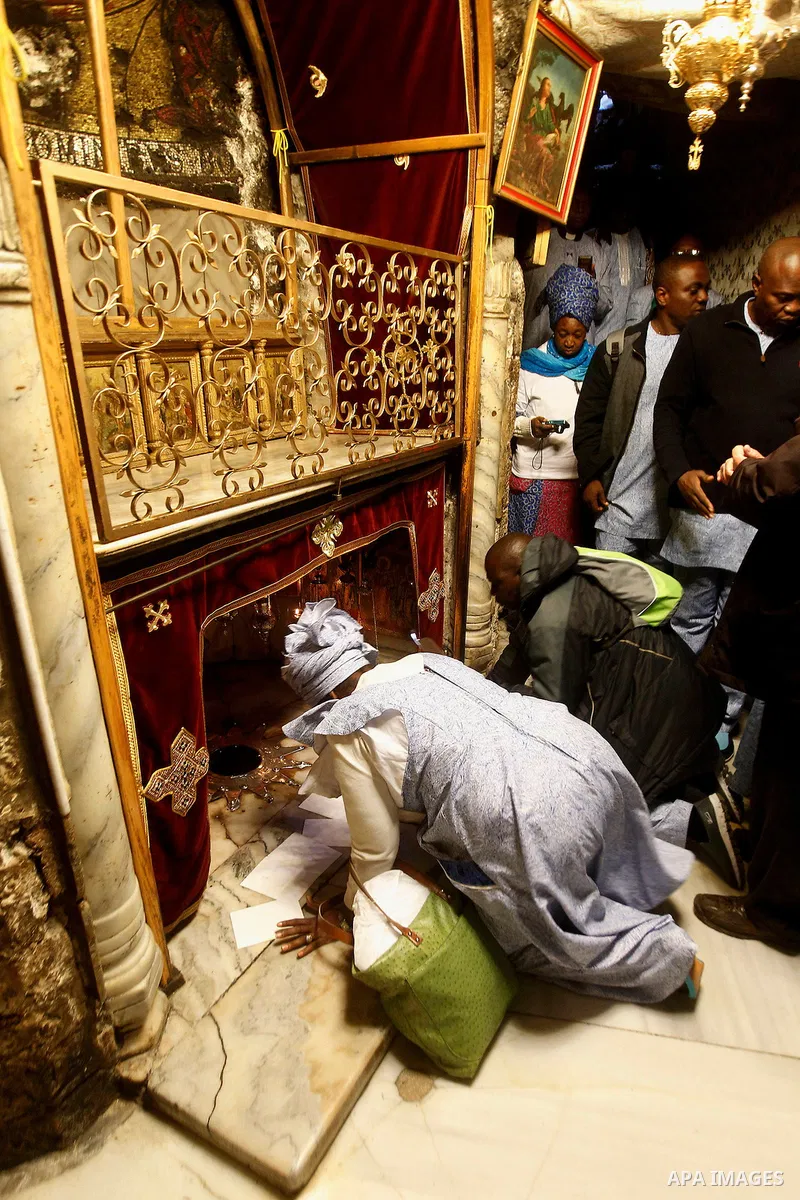 Africans Christian pilgrims look to a 14-point silver star on the marble floor of the Grotto in the Church of the Nativity, believed to be the birthplace of Jesus Christ, in the West Bank city of Bethlehem on December 22...