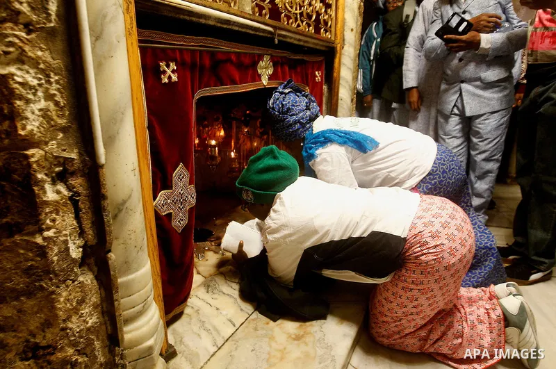 Africans Christian pilgrims look to a 14-point silver star on the marble floor of the Grotto in the Church of the Nativity, believed to be the birthplace of Jesus Christ, in the West Bank city of Bethlehem on December 22...