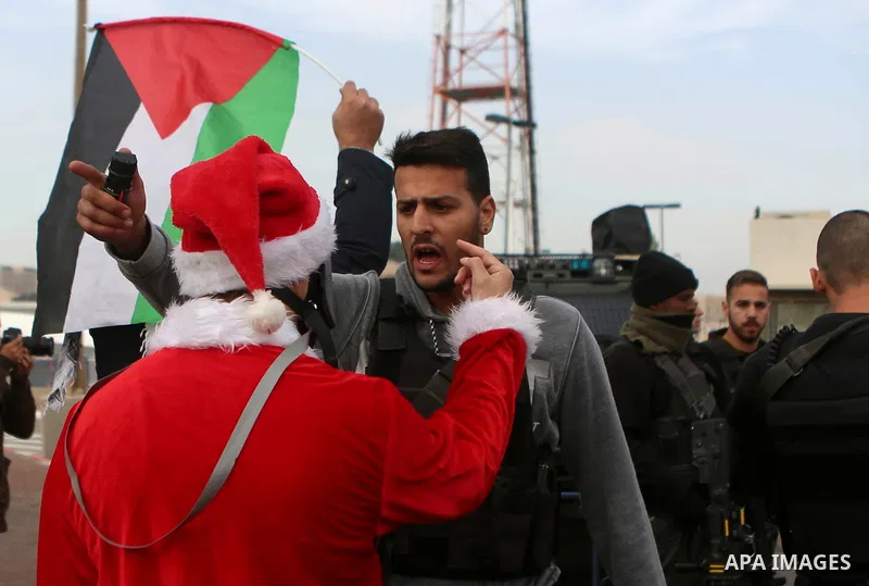 A Palestinian protester dressed up as Santa Claus argues with an Israeli border guard during clashes at a demonstration next to a section of Israel's separation wall in the biblical town of Bethlehem, in the occupied Wes...