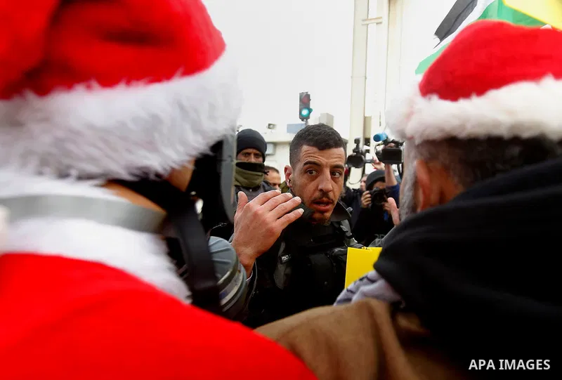A Palestinian protester dressed up as Santa Claus argues with Israeli border guard during clashes at a demonstration next to a section of Israel's separation wall in the biblical town of Bethlehem, in the occupied West B...