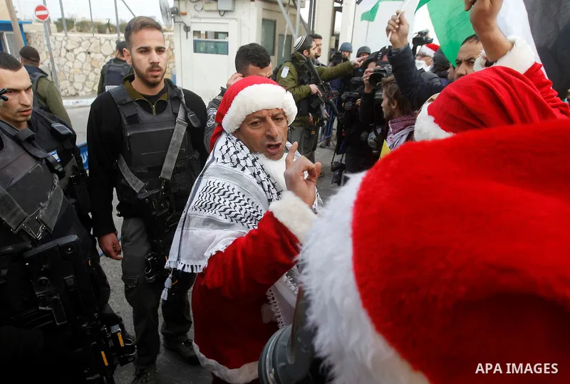 A Palestinian protester dressed up as Santa Claus argues with Israeli border guard during clashes at a demonstration next to a section of Israel's separation wall in the biblical town of Bethlehem, in the occupied West B...