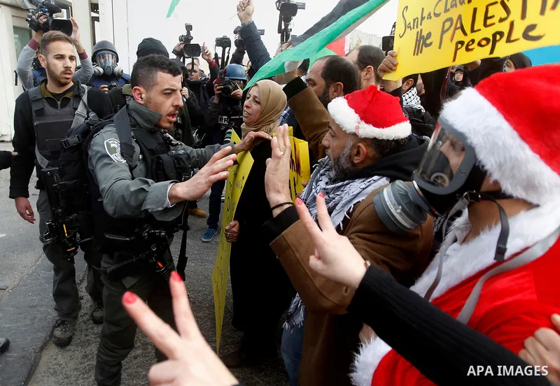 Palestinian protesters argue with Israeli border guard during clashes at a demonstration next to a section of Israel's separation wall in the biblical town of Bethlehem, in the occupied West Bank, on December 23, 2016. P...