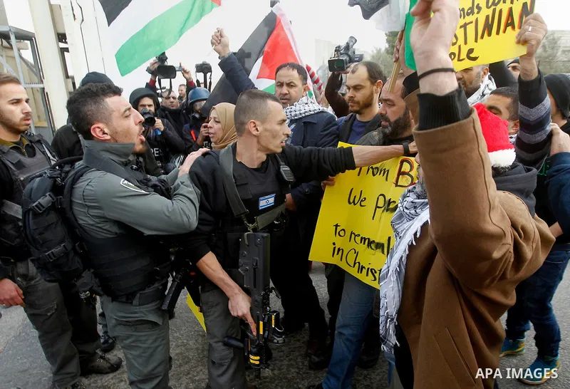 A Palestinian protester dressed up as Santa Claus argues with Israeli border guard during clashes at a demonstration next to a section of Israel's separation wall in the biblical town of Bethlehem, in the occupied West B...