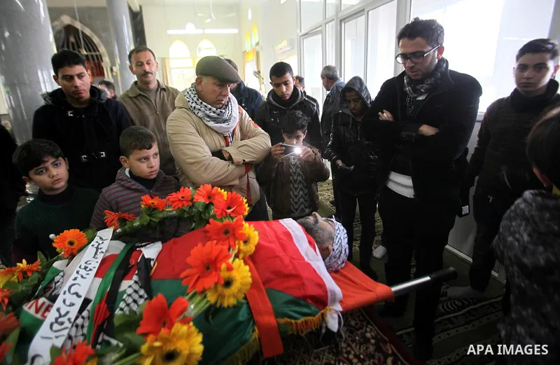 Mourners gather around the body of Palestinian Jihad Khalil, who according to the Israeli police was shot and killed by an Israeli security guard after Khalil tried to stab him last November, during his funeral after Isr...