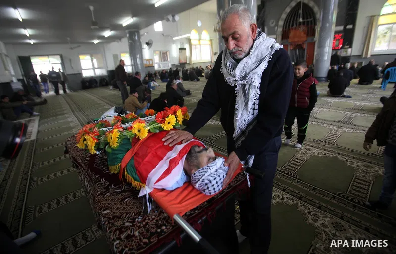 Mourners gather around the body of Palestinian Jihad Khalil, who according to the Israeli police was shot and killed by an Israeli security guard after Khalil tried to stab him last November, during his funeral after Isr...