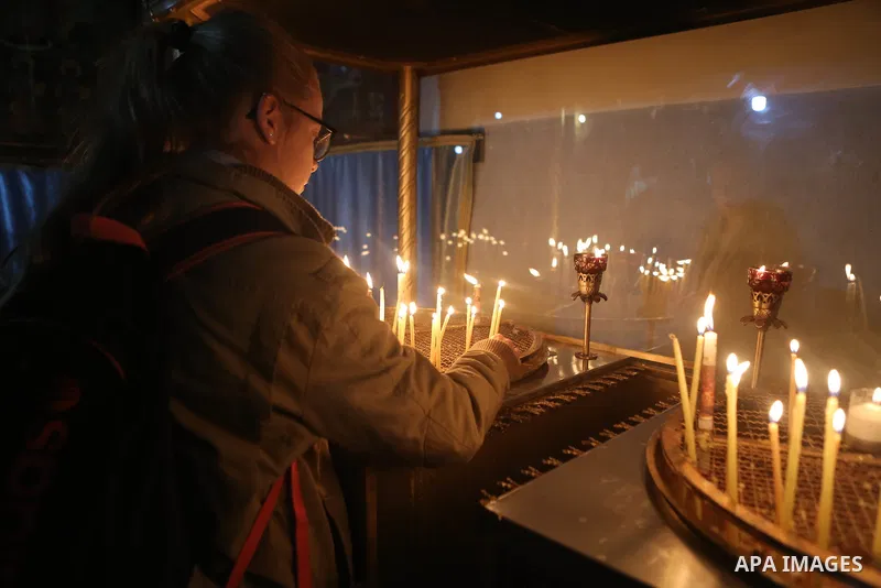 A visitor lights a candle inside the Church of the Nativity in the West Bank town of Bethlehem December 24, 2016. Photo by Shadi Hatem
