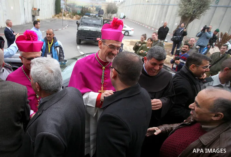 The Latin Patriarch of Jerusalem Pierbattista Pizzaballa is greeted upon his arrival through an Israeli checkpoint to attend Christmas celebrations, in the West Bank city of Bethlehem December 24, 2016. Photo by Wisam Ha...
