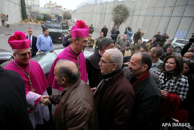 The Latin Patriarch of Jerusalem Pierbattista Pizzaballa is greeted upon his arrival through an Israeli checkpoint to attend Christmas celebrations, in the West Bank city of Bethlehem December 24, 2016. Photo by Wisam Ha...