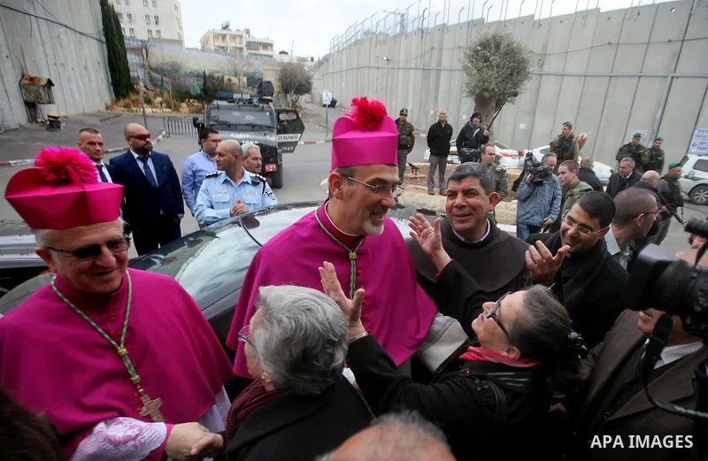 The Latin Patriarch of Jerusalem Pierbattista Pizzaballa is greeted upon his arrival through an Israeli checkpoint to attend Christmas celebrations, in the West Bank city of Bethlehem December 24, 2016. Photo by Wisam Ha...