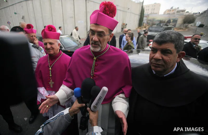 The Latin Patriarch of Jerusalem Pierbattista Pizzaballa is greeted upon his arrival through an Israeli checkpoint to attend Christmas celebrations, in the West Bank city of Bethlehem December 24, 2016. Photo by Wisam Ha...