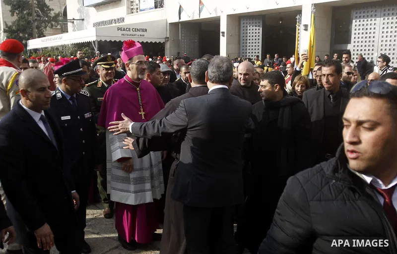 The Latin Patriarch of Jerusalem Pierbattista Pizzaballa is greeted upon his arrival through an Israeli checkpoint to attend Christmas celebrations, in the West Bank city of Bethlehem December 24, 2016. Photo by Wisam Ha...