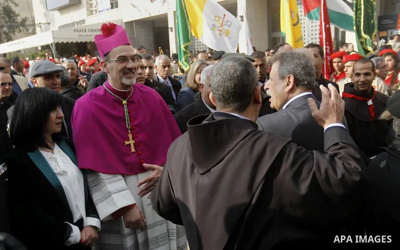 The Latin Patriarch of Jerusalem Pierbattista Pizzaballa is greeted upon his arrival through an Israeli checkpoint to attend Christmas celebrations, in the West Bank city of Bethlehem December 24, 2016. Photo by Wisam Ha...