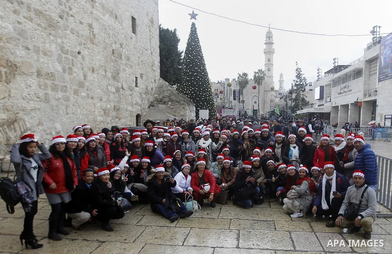 Palestinians attend a Christian scouts performance at the Manger Square outside the Church of the Nativity during Christmas celebrations, in the city of Bethlehem in the Israeli-occupied West Bank, on December 24, 2016....