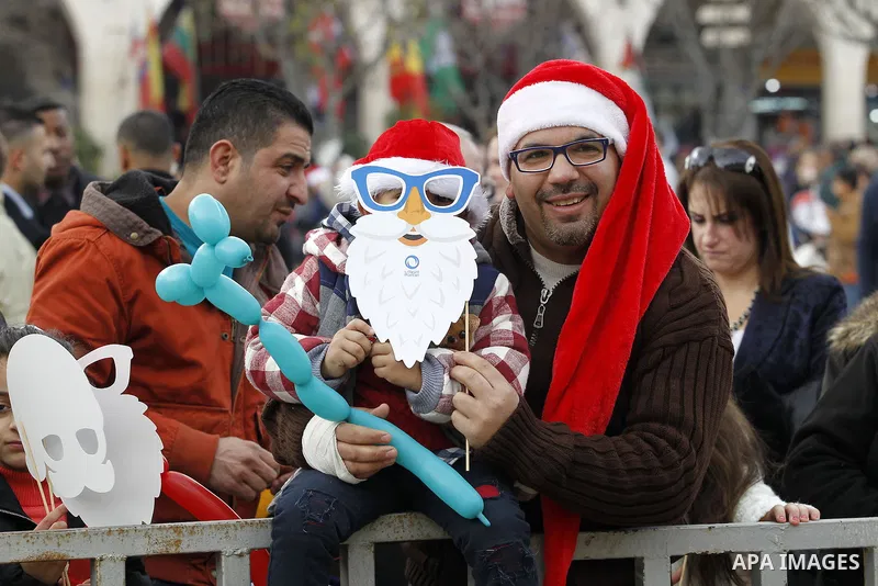 Palestinians attend a Christian scouts performance at the Manger Square outside the Church of the Nativity during Christmas celebrations, in the city of Bethlehem in the Israeli-occupied West Bank, on December 24, 2016....