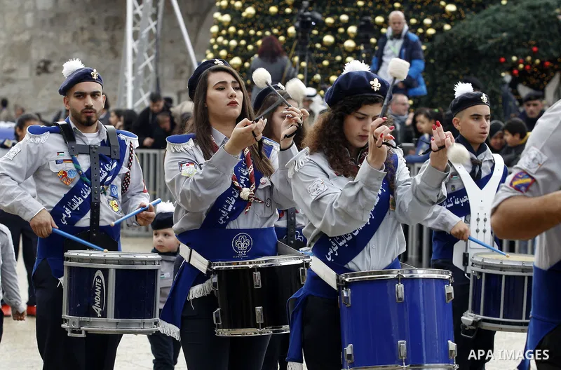 Palestinian Christian scouts perform at the Manger Square outside the Church of the Nativity as people gather for Christmas celebrations in the city of Bethlehem in the Israeli-occupied West Bank, on December 24, 2016. P...