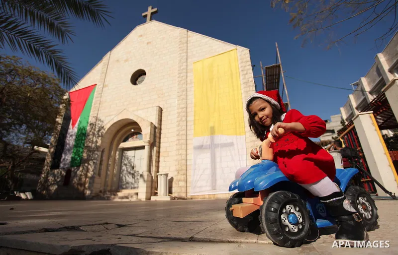 Palestinian Christians attend Christmas mass at Der Latin church, in Gaza City on December 25, 2016. Photo by Ashraf Amra