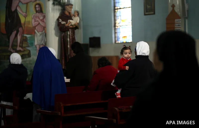 Palestinian Christians attend Christmas mass at Der Latin church, in Gaza City on December 25, 2016. Photo by Ashraf Amra