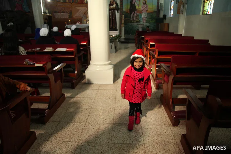 Palestinian Christians attend Christmas mass at Der Latin church, in Gaza City on December 25, 2016. Photo by Ashraf Amra