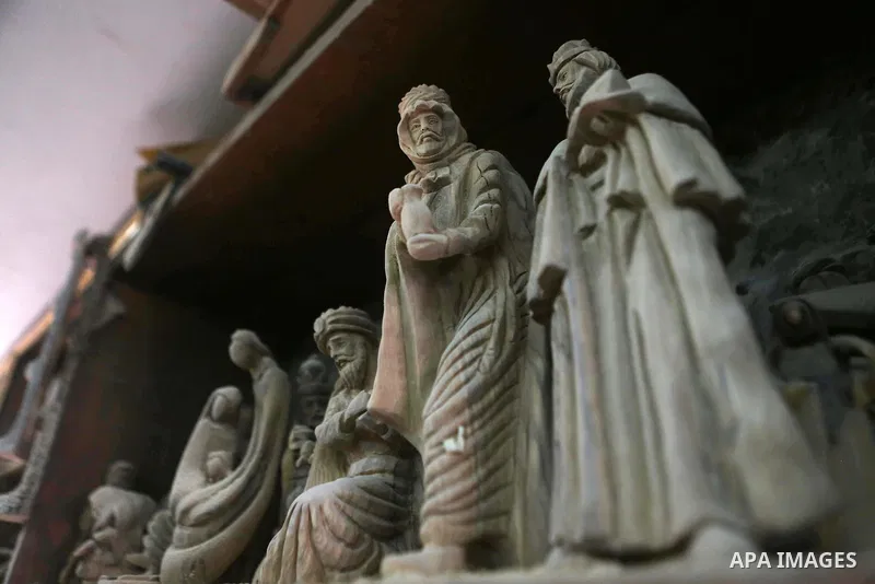 A woden effigies of the the Holy Family are seen at a workshop in the West Bank town of Bethlehem, on December 26, 2016. The traditional birthplace of Jesus Christ prepares to celebrate Christmas. Photo by Shadi Hatem