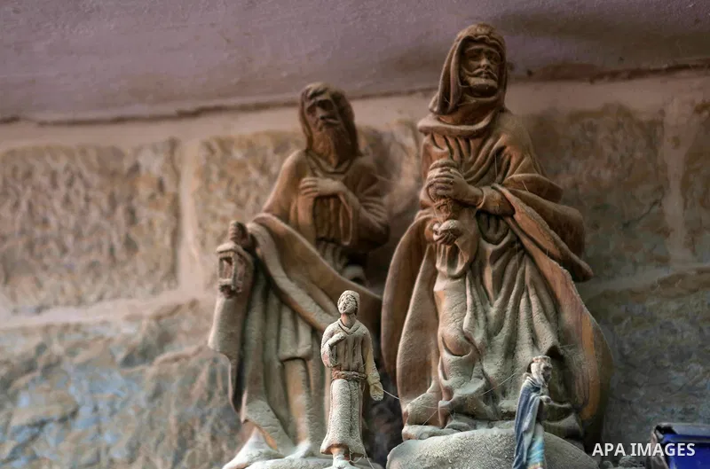A woden effigies of the the Holy Family are seen at a workshop in the West Bank town of Bethlehem, on December 26, 2016. The traditional birthplace of Jesus Christ prepares to celebrate Christmas. Photo by Shadi Hatem