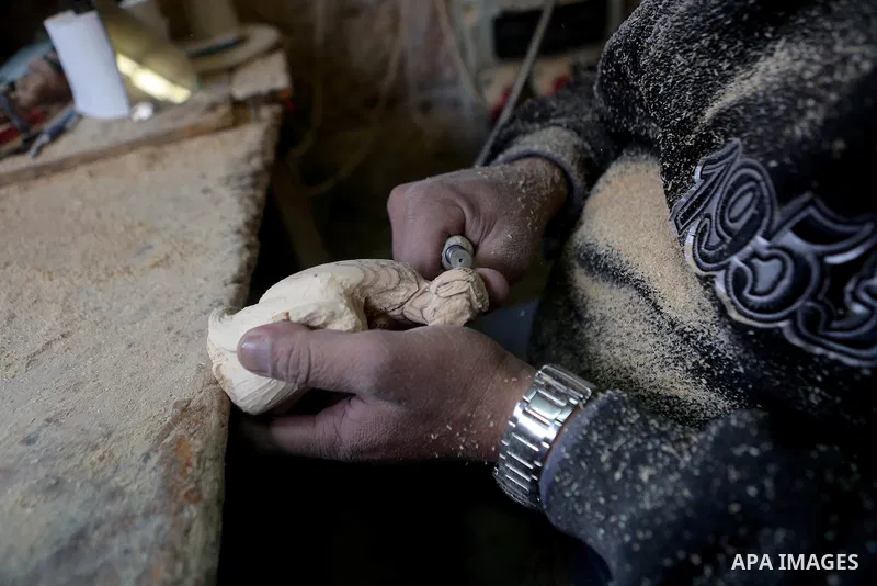 A Palestinian carpenter carves a wooden effigies of the the Holy Family at a workshop in the West Bank town of Bethlehem, on December 26, 2016. The traditional birthplace of Jesus Christ prepares to celebrate Christmas....